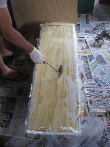 Rolling the fibreglass to squeeze out air